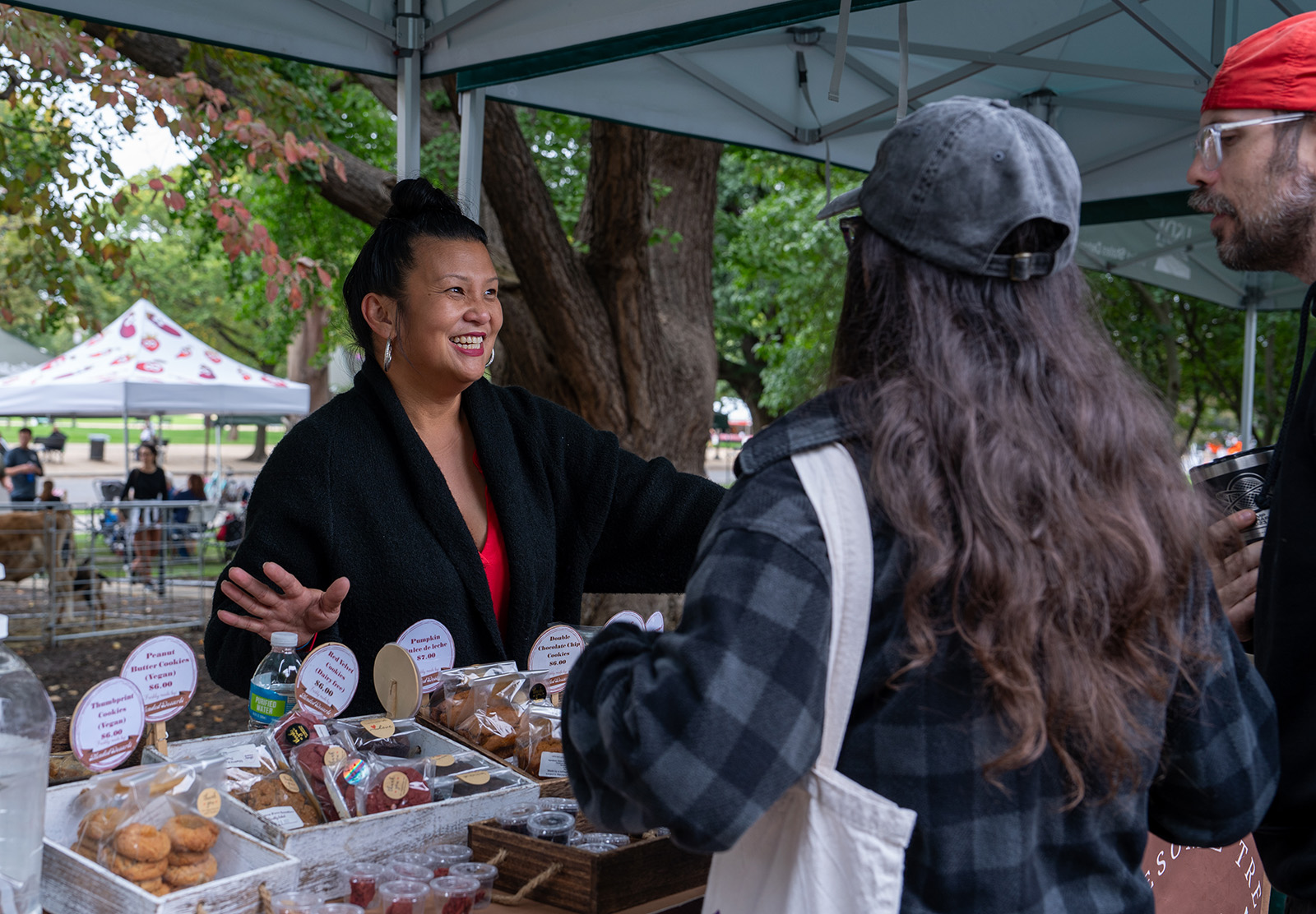 Farmstand worker interacting with customers.